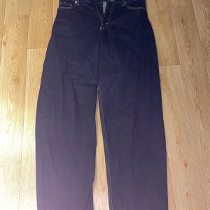 Mörkblå jeans från Weekday - Säljer ett par snygga mörkblå baggyjeans från Weekday i modellen Rail. De är högmidjade men blir låga om man har liten midja, så ha ett skärp till, aldrig använda mer än att jag provat dem.