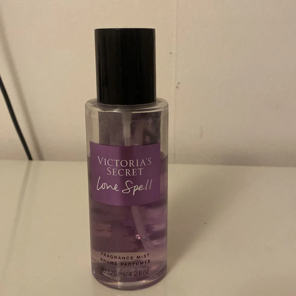 Säljer en Love Spell Fragrance Mist från Victoria's Secret. Den har en lila etikett och innehåller 125 ml av en fräsch och blommig doft. Perfekt för daglig användning eller speciella tillfällen. Flaskan är genomskinlig med en svart kork.  Pris diskuterbart . Parfym.