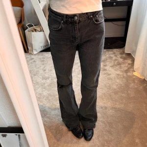 Gina Tricot jeans - Jeans från Gina Tricot i grå bootcut modell med hål på ena knät. Jeansen är rätt långa och perfekta till klackar🩷