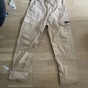 Cargobyxor - Säljer ett par beigea cargobyxor från scotch and soda. Stl S. Normal passform