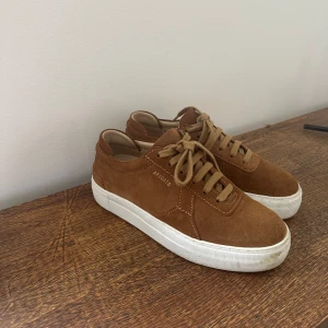 Arigato sneakers - Skorna är använda ett fåtal gånger, utöver den otvättade sulan är dom i jättefint skick! Brun mocka, med en högre sula.