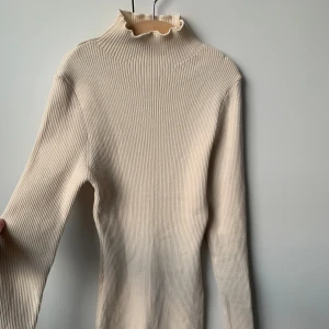 Beige klänning  - Åtsittande beige kort klänning som formar sig efter kroppen. Ganska liten i storleken så skulle säga att den är S/M