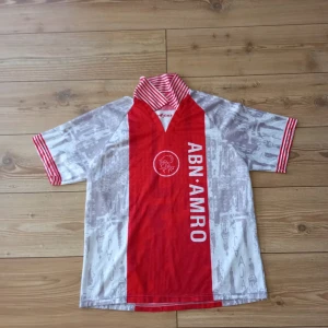 Fotbollströja Ajax - Säljer nu den hära jättesnygga fotbollströja från Ajax under 90 talet. Skick:6/10, finns flertals lösa tråd men snygg för samlare! Storlek: står S men passar även M. 