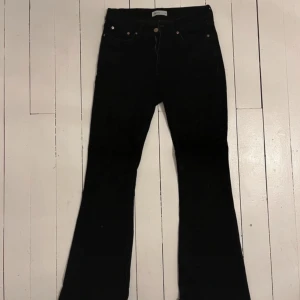 Svarta jeansbyxor - Säljer ett par klassiska svarta jeansbyxor. De har en snygg och tidlös design med en bootcut-stil som ger en skön passform. Perfekta för både vardag och fest!
