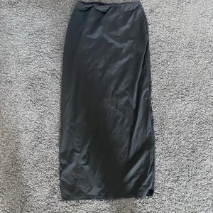 Svart långkjol - Fin svart långkjol. Med slits på baksidan och spets i midjan. 