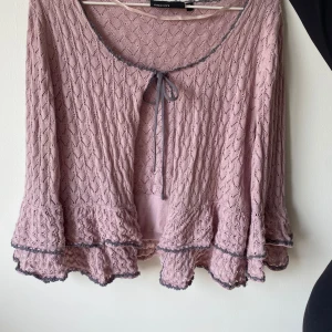 Ljusrosa spetskofta från KappAhl - Säljer en superfin ljusrosa spetskofta från KappAhl. Den har en söt knytning framtill och volangdetaljer vid ärmslut och nederkant. Perfekt för vår och sommar! 💕