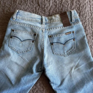 Lågmidijade Ljusblå jeans - Ett par jätte fina lågmidijade ljusblå jeans från Reactive med skit snygga fickor. Passformen är 34 och midjemåttet rakt över är ungefär 30-35. Jag är 170 och dom är lite långa på mig men funkar att ha. Det är bootcut💕
