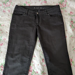 Svarta capribyxor i jeansmaterial - Svarta capribyxor med diamantknapp och -detaljer i strl. 40. De är lågmidjade, typiskt Y2K. Superfint skick, köpta second hand. De täcker knäna och en del av vaden på mig som är 167 cm. Säljer då de är för stora!
