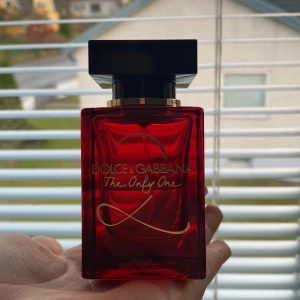 Röd parfymflaska från Dolce & Gabbana - Säljer en elegant röd parfym från Dolce & Gabbana, 'The Only One'. Perfekt för den som vill ha en lyxig doftupplevelse. Passar både till vardags och fest! Väldigt stark doft som håller länge och flaskan det är hälften kvar i flaskan. 