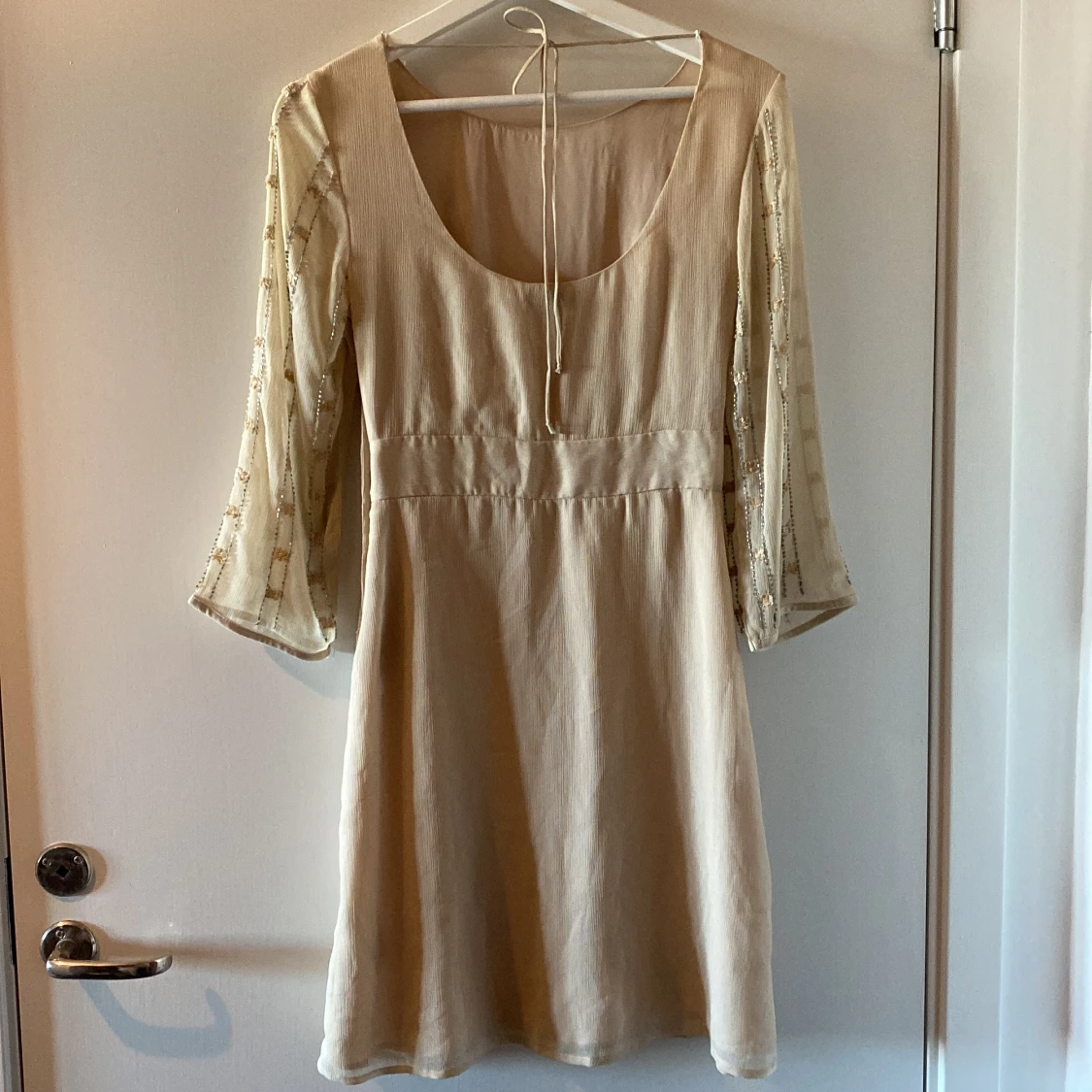 Beige klänning med paljettdetaljer - 92