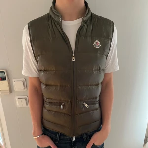 Olivgrön Gui-väst från Moncler - Säljer nu denna sjukt snygga Gui västen från moncler i en trendig och extremt snygg olivgrön färg perfekt till höst, vår och vinter endast för 1599🤩🤩Pris ej hugget i sten🪨🤗Storlek:3 Cond:9/10 Nypris: 7900 