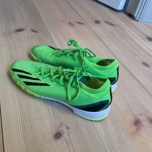 Gröna fotbollsskor från Adidas - Säljer ett par gröna innomhus fotbollsskor från Adidas i bra skick. Skorna har en snygg design med svarta och gula detaljer och är perfekta för fotbollsträning. De har snörning och en slitstark sula som ger bra grepp på planen. Använda men bra skick lite små skavanker som visas på bild 4 och 5! Skriv för fler bilder samt om ni undrar något🩷