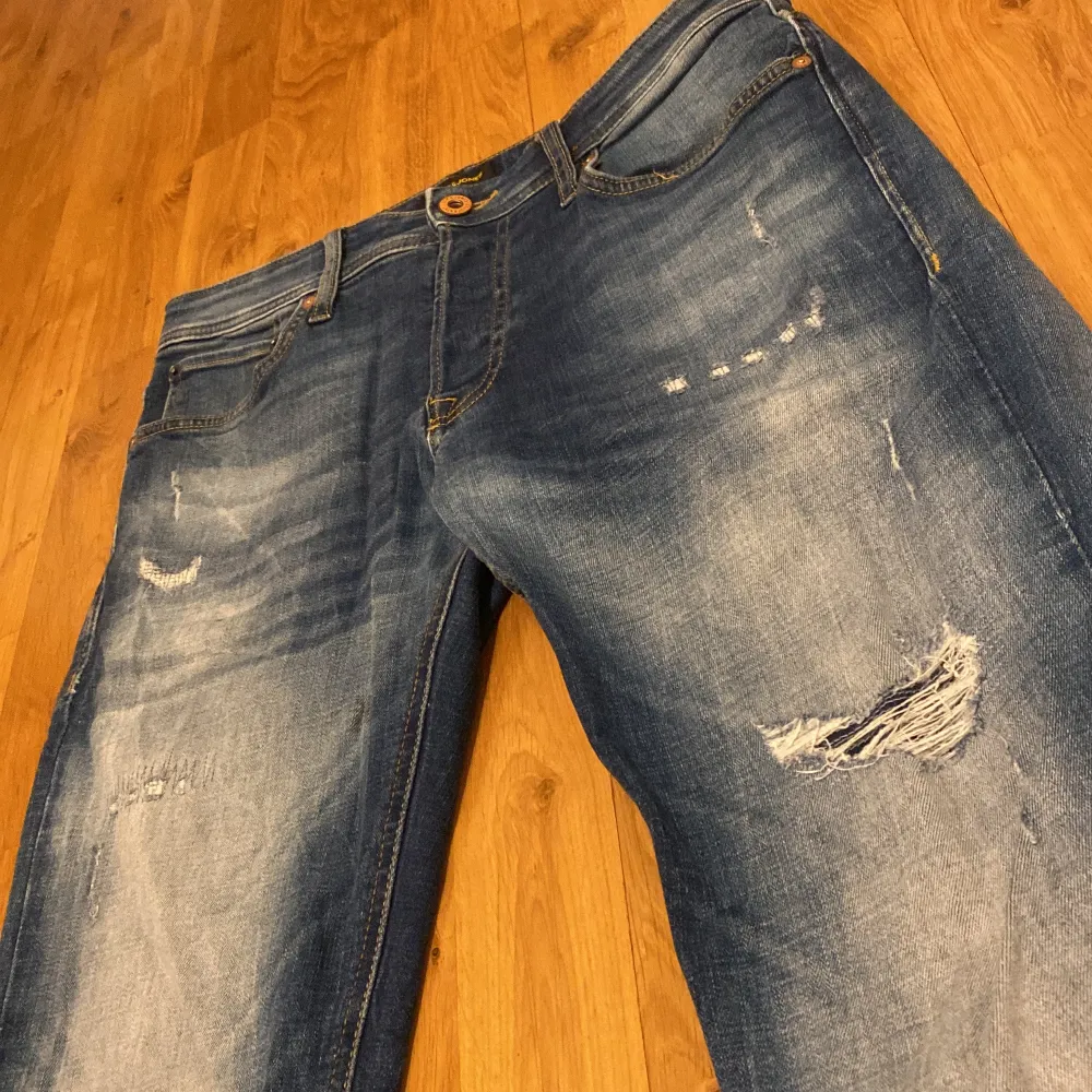 Säljer ett par snygga blå jeans från Jack & Jones i modellen Comfort/Mike. Snygg slitningsdesign (inga hål) och är i väldigt bra skick. Använda i någon vecka, sitter perfekt. Jeans & Byxor.