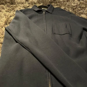 Mörkblå overshirt med dragkedja - Säljer en stilren mörkblå overshirt med dragkedja framtill. skicket är 10/10 aldrig använt den förrut, i och med att den är för stor. priset är 449, bara skriva för fler frågor/bilder😀