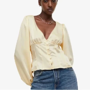 Gul blus med knappar - Säljer denna super fina gula blus med v-ringning och knappar framtill! Blusen har en figursydd passform i midjan. Bilderna är lånade!! Säljer pågrund utav att den ej kommer till användning! Perfekt för både vardag och fest! Hör av er vid frågor och funderingar, pris går att diskutera!❤️