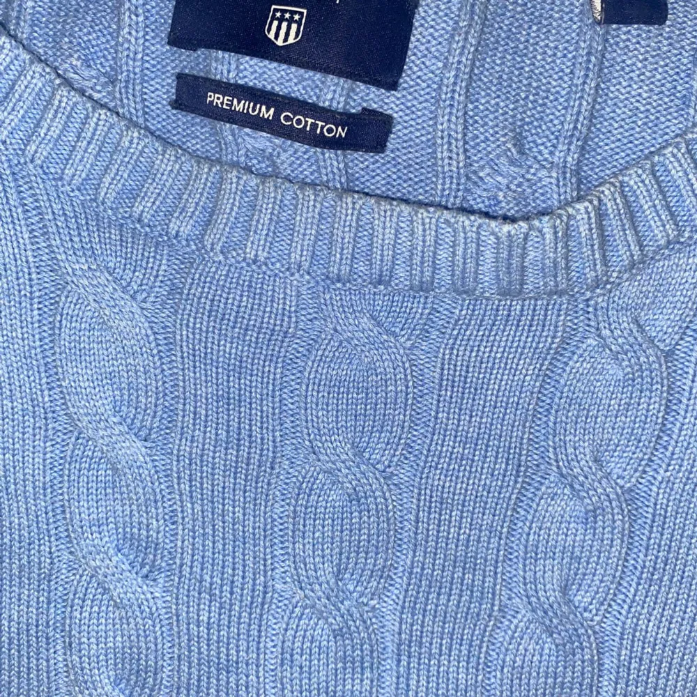 Säljer en snygg ljusblå kabelstickad tröja från Gant i premium bomull. Perfekt för både höst och vår. Tröjan har en klassisk design med rund hals och långa ärmar. Den är i mycket bra skick och redo för nya äventyr! 💙. Neuletakit & Villapaidat.