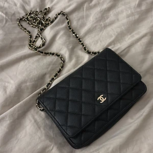 Svart quiltad axelväska - Säljer en elegant svart quiltad axelväska från i  bra skick. Väskan har en kedjerem i guld och är klassisk. Perfekt för både vardag och fest! Priset går att diskutera vid snabb affär!