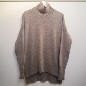 Stickad tröja i Taupe 100 % kashmir modell Heidi från Lisa Yang  - Stickad tröja i färgen Taupe, modell Heidi med hög krage 100% fin kashmir från Lisa Yang. Samma modell som Mila fast med hög krage. Nypris 4900 kr. Storlek 0 = S/M. Tröjan är i nyskick. Köparen står för fraktkostnaden.