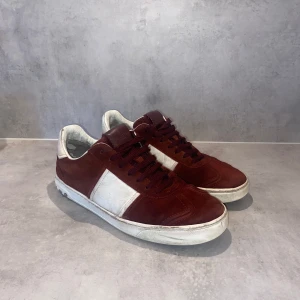 Vinröda sneakers från Valentino - Säljer ett par snygga flycrews i storlek 40 men passar 41. Relativt gott skick, 7/10. 12/22 nitar kvar. Dustbag medföljer. Hör gärna av er vid fler frågor eller bilder