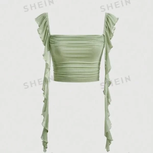 Grön volangtopp  - Snygg grön topp med volangdetaljer. Den har en tight passform och är perfekt för sommaren. Toppen är ärmlös med axelband och har en stilren design som passar både till vardags och fest. Storlek M men mer som S.