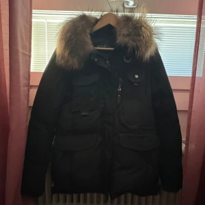 Svart vinterjacka från Hollies - Säljer en snygg svart vinterjacka från Hollies i storlek 42. Jackan har en fluffig pälsdetalj på huvan och flera praktiska fickor framtill. Perfekt för kalla vinterdagar! 🖤1500kr ev kan gå ner till 1000kr.