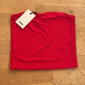 Röd tubtopp  - Snygg röd tubtopp från Bikbok. Aldrig använd med prislappen kvar, pris kan diskuteras 