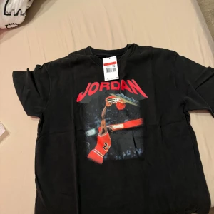 Jordan svart blå T-shirt, storlek L - Säljer helt nya två stycken t-shirts från Jordan. Båda är i storlek L och har en cool design med en bild av Michael Jordan. Den ena är svart och den andra är blå.  Lapparna sitter kvar!