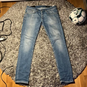 Blå jeans från dondup - Säljer ett par snygga ljusblå jeans från dondup i storlek 31. De har en slim passform och är perfekta för både vardag och fest. Jeansen har en klassisk femficksdesign och är i mycket bra skick. Perfekta för vår och sommar!