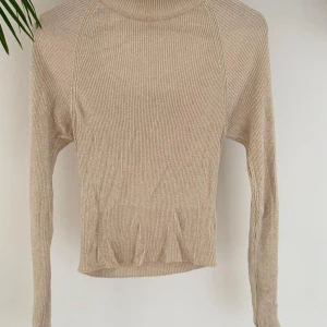 Beige ribbad halvpolo, Gina Tricot - Snygg beige ribbad tröja från Gina Tricot med långärmad design. Halvpolo som går att ha på båda håll, något cropad.