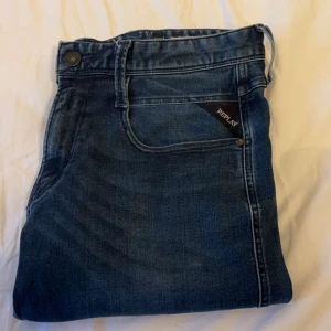 Blå jeans från Replay Anbass - Hej, säljer dessa replay jeans som är i modell anbass. Jeansen är i ett fint skick. Jeansen är i W29 men kan lösa mått om man är osäker på längden. Jeansen har inga deffekter eller täcken på användning och kostar i ny pris ca 1800kr.