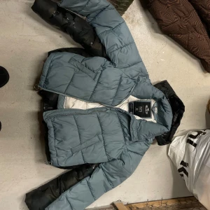 Blå pufferjacka från Hollister - Säljer en cool pufferjacka från Hollister i blått. Jackan har en dragkedja framtill. Den har en modern look och är vadderad för extra värme.