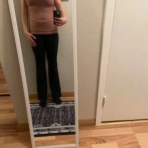 Beige ribbad topp - Snygg beige ribbad topp med korta ärmar och en smickrande passform. Perfekt för en stilren look.