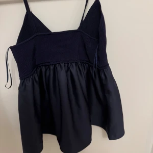 Mörkblå  topp - Söt mörkblå topp med smala axelband och en kombination av stickat och satinmaterial.