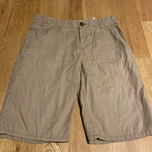 Chinos shorts  - Säljer ett par stilrena beige shorts med knapp och dragkedja. De har en klassisk design med fickor på sidorna och är perfekta för en avslappnad look. Passar bra till varma dagar.