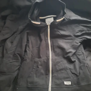 Svart hoodie  - Svart hoodie med dragkedja, luva och fickor. Lager 157