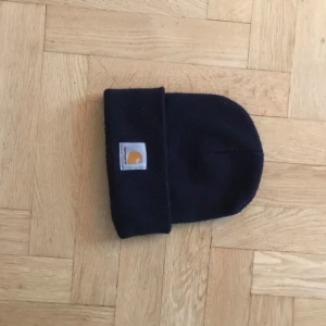 Carhartt mössa i mörkblå färg, no size - Den är i one size, använd men i bra skick. Mössan har en mörkblå färg.  Pris kan diskuteras 