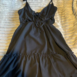 Svart klänning - Jättefin svart klänning som tyvärr aldrig kommit till användning då den är för stor för mig. Knytning framme