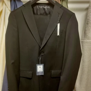 Helt Ny och Oanvänd Kostym - Helt ny och oanvänd Kostym i Regular Slim Fit från Dressman. Byxa 32 30 Kavaj 48R Köpte tre kostymer inför mitt bröllop för att testa hemma. Jag använde bara en av dem, returnerade den andra och tappade bort kvittot till den tredje. Nypris 2499 :-