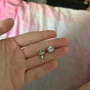 Silvriga örhängen - Silverörhängen med diamantsten i mitten. Fina till vardags men också perfekta för en enkel uppklädd outfit. Oanvända, endast borttagen förpackning.