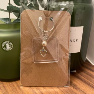 Personlig nyckelring  - Gullig genomskinlig nyckelring i kvadratform med en hjärtberlock och pärla. Passar både till egenbruk och som en söt present! 🩶Kolla gärna resten av mina annonser för samfrakt.