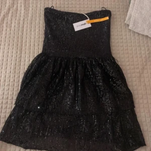 Glittrig klänning - En fin glittrig klänning från Ginatricot, helt ny endast testad!