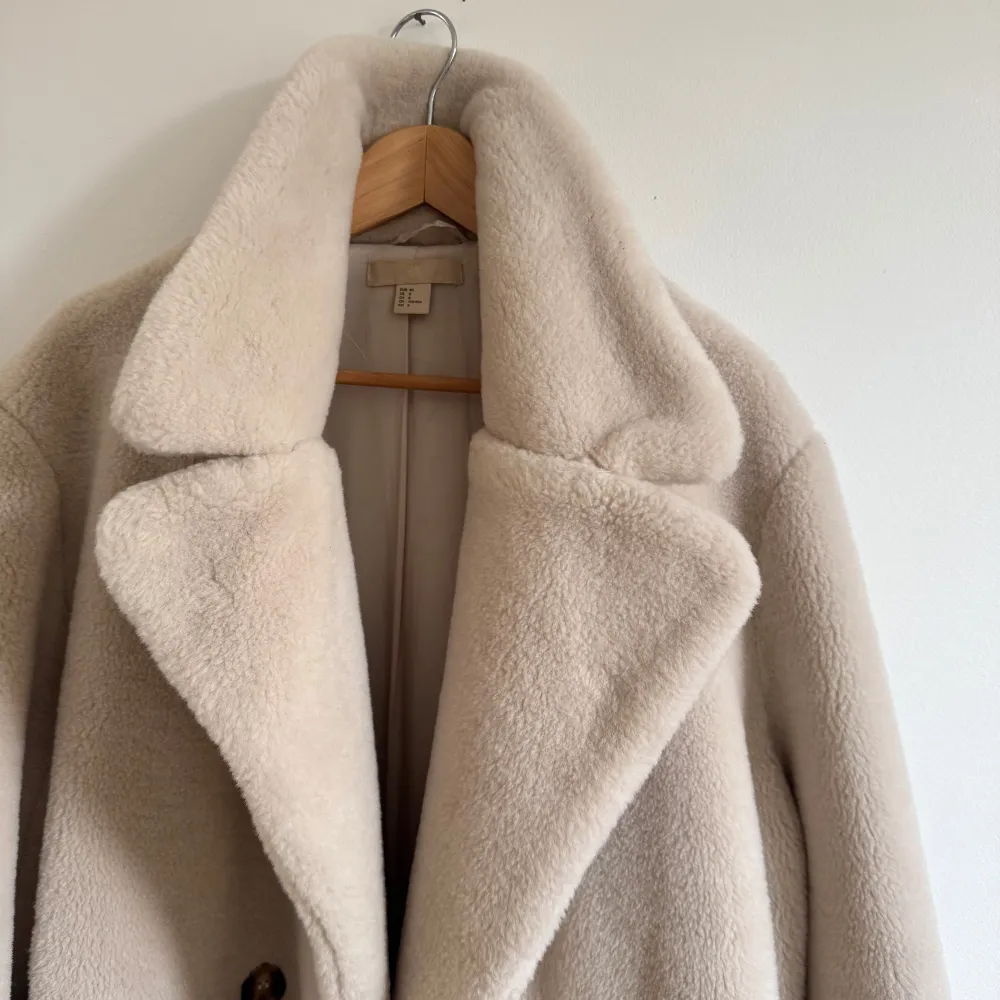 Säljer en supermysig beige teddyjacka /päls från H&M i storlek 40. Den har en klassisk design med stora knappar framtill och långa ärmar. Perfekt för kalla höst- och vinterdagar när du vill hålla dig varm och stilren. Jackan är i nyskick!. Jackor.