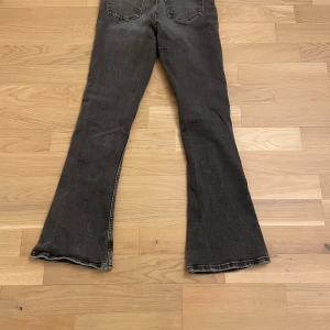Svart/gråa bootcut jeans - Ett par snygga svart/gråa jeans med passformen bootcut. Trendiga och populär!😁💕 De har dock lite slitningar nere vid slutet av benen, ska påminnas om att modellen var så när de köptes men lite har kommit efter tiden.