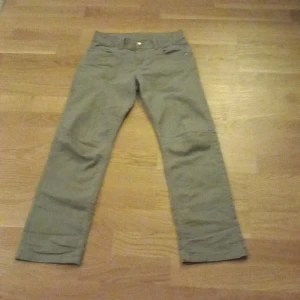 Beige byxor från kappAhl - Säljer ett par beige byxor i bra skick. De har en klassisk design med knappar och dragkedja framtill. Perfekta för både vardag och lite mer uppklädda tillfällen. Passar bra till höst och vår.