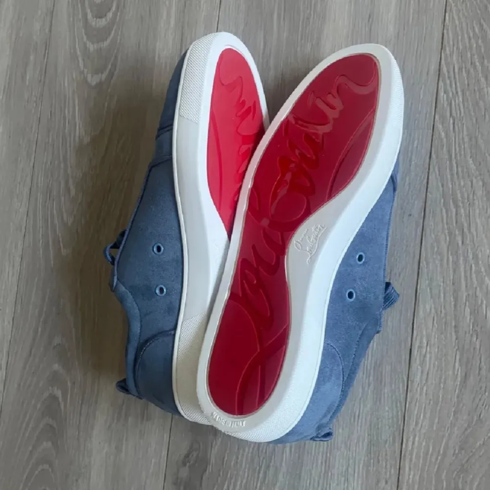 Säljer ett par snygga blå sneakers från Christian Louboutin i mycket bra skick. Skorna har den ikoniska röda sulan och är gjorda i mocka med snörning. Perfekta för både vardag och fest! Kommer med originalförpackning och dustbag.. Skor.