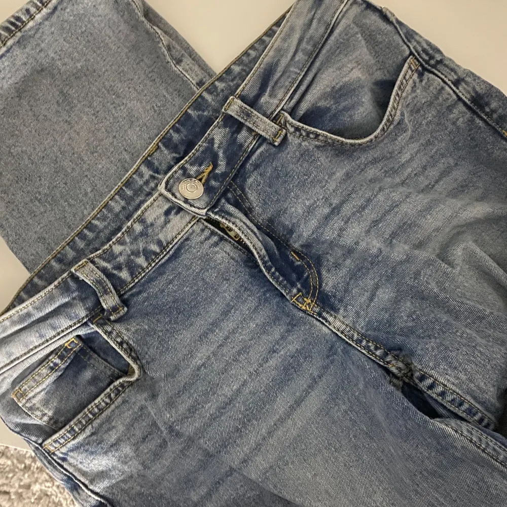 Säljer ett par klassiska blå jeans i bra skick. De har en normal passform och är perfekta för vardagsbruk. Jeansen har en knapp och dragkedja framtill samt fem fickor. Perfekta för både höst och vår!. Jeans & Byxor.