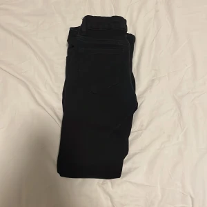 Svarta byxor med bootcut - Säljer ett par svarta byxor i bootcut-stil. De är perfekta för både vardag och fest. Byxorna har en knapp och dragkedja framtill. De är i bra skick och passar till många olika outfits. Perfekta för höst och vinter!