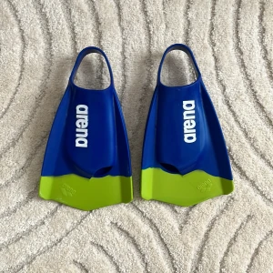 Blå och gröna simfenor från Arena - Säljer ett par blå och gröna simfenor från Arena. Perfekta för simträning och ger bra fart i vattnet. De är märkta med storlek EU 38-39 och har en bekväm passform.