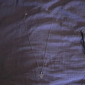 Silverfärgat halsband med vikingar symboler - Elegant silverfärgat halsband med en triangulär hänge dekorerad/vikingar symbol. Ett lite längre halsband.
