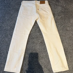 Beige/vita jeansbyxor från Levis - Snygga beige jeansbyxor från Levis med klassisk femficksdesign. Byxorna har en rak passform då det är 501or. De är tillverkade i ett slitstarkt material och har en knappgylf. Dem är använda ett 2 gånger sen jag köpte dem. Storlek är W31 L30. Köpta för 1100kr från Levis i Helsingborg. Pris kan diskuteras vid snabbbb affär 